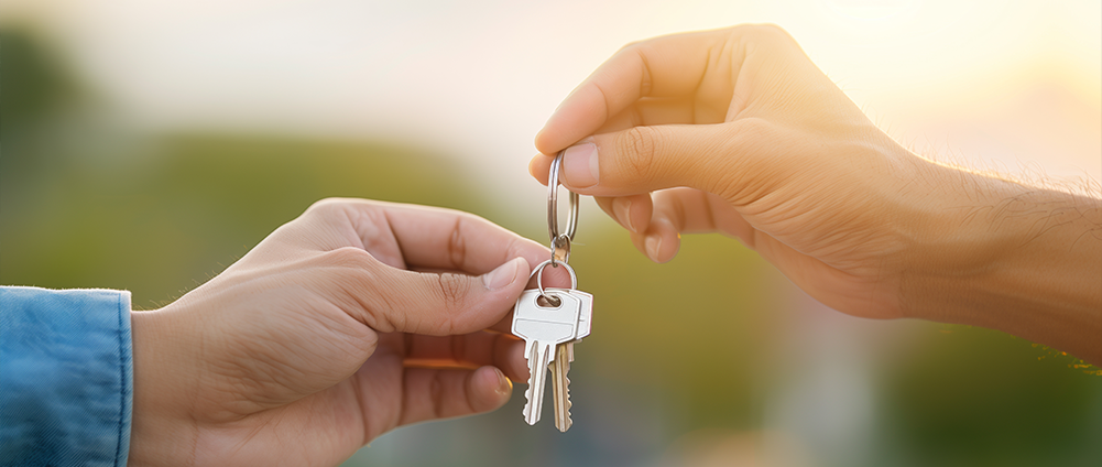 Hands passing keys to introduce unlocking your future with AWM&T's 2025 IRA Disclosures.