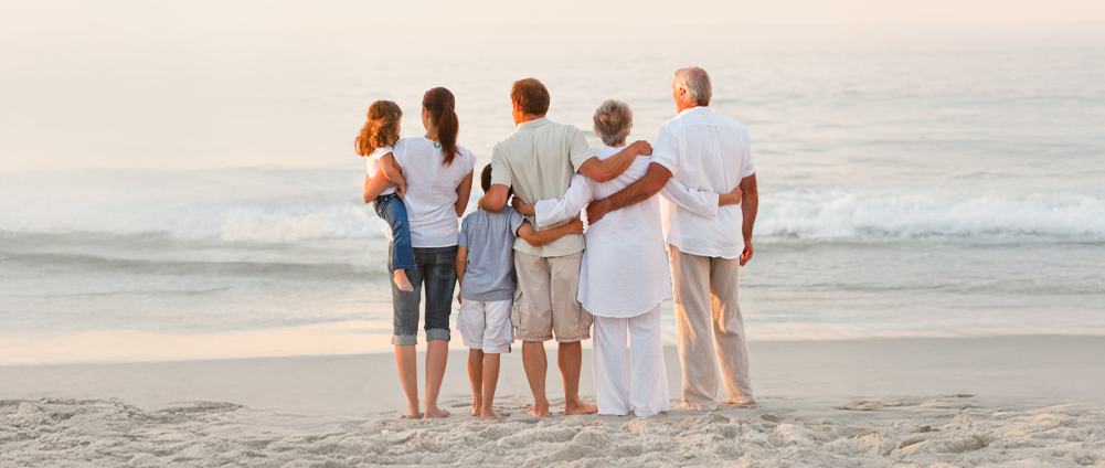 Military family on the beach hugging, enjoying generational wealth with the help of AAFMAA Wealth Management & Trust LLC (AWM&T)