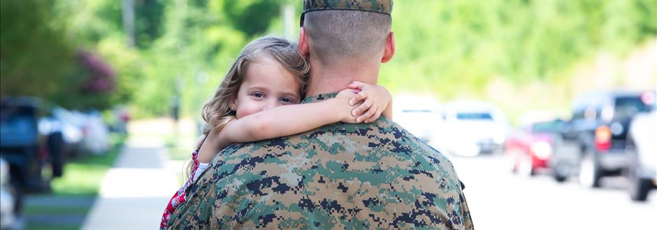little girl hugging military dad
